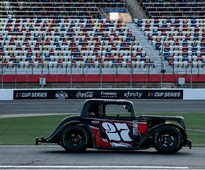 Race car on track with grandstands behind